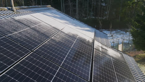 aerial view backwards over frosty, solar panels, melting on a sunny house roof