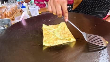 roti being pan-fried by a street vendor