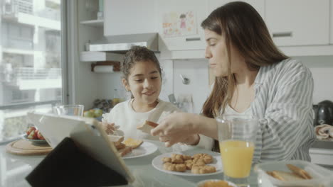 mother and little daughter enjoying breakfast at home