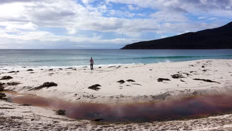 Un-Hombre-Camina-Por-La-Arena-En-Una-Playa-Aislada-En-Un-Hermoso-Día