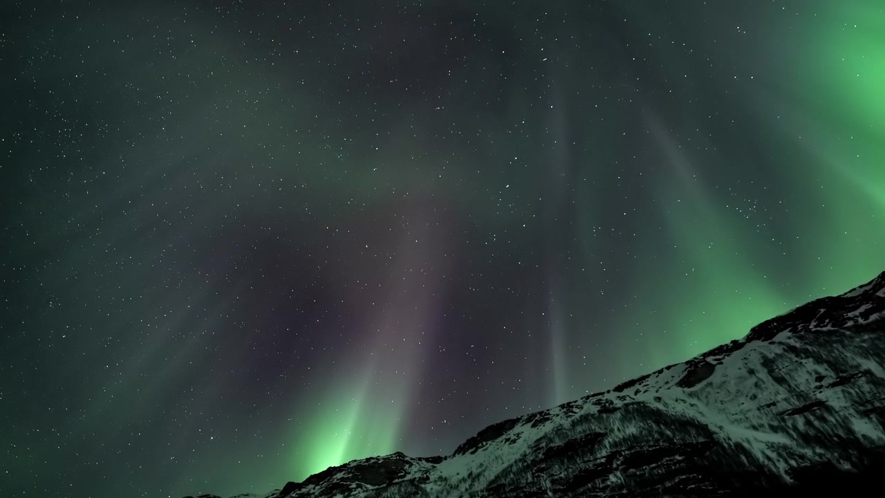 Vibrante Aurora Boreale che Danza sulle Cime Montuose Innevate