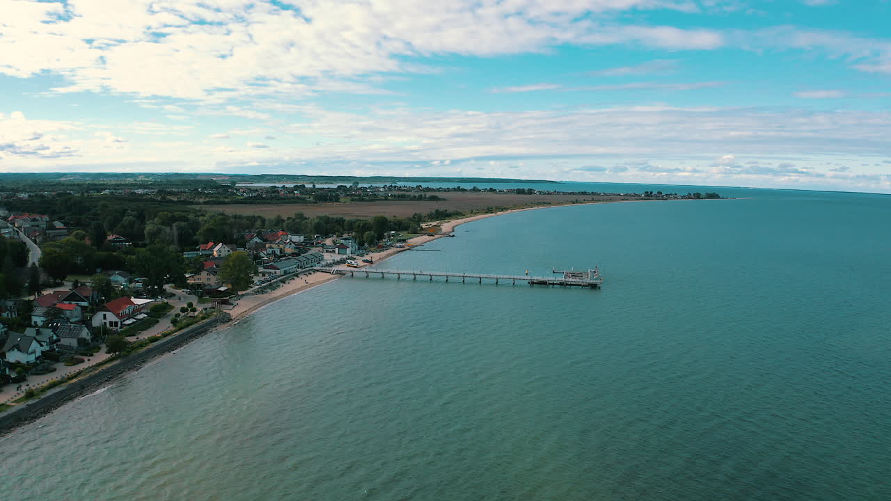 vista aérea de un dron volando sobre el muelle en mechelinki, polonia con el mar báltico en el fondo