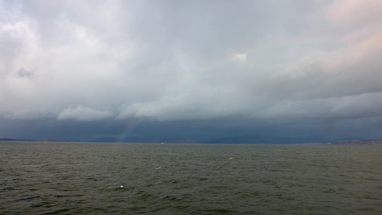 mull 섬으로 항해하는 페리에서 바다 위의 무지개를 손으로 찍은 사진