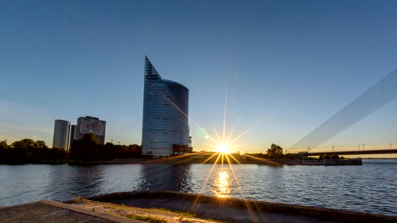 timelapse de la puesta de sol con el edificio de negocios banco rascacielos en el centro de la ciudad de riga