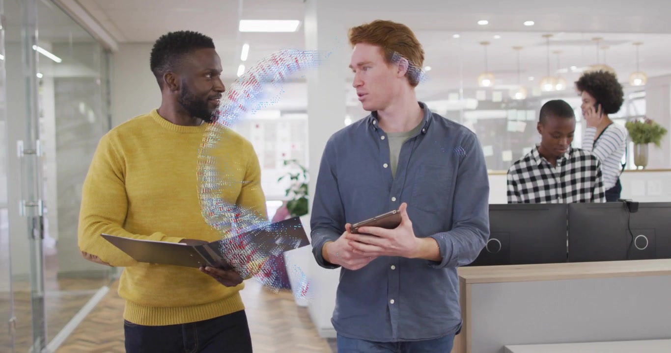 Two coworkers walking in office reviewing tech project scrolling tablet projecting 3D data globe