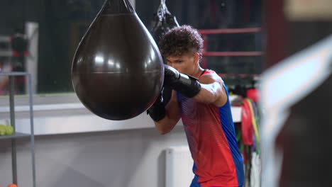 un boxeador joven practicando golpes en una bolsa pesada