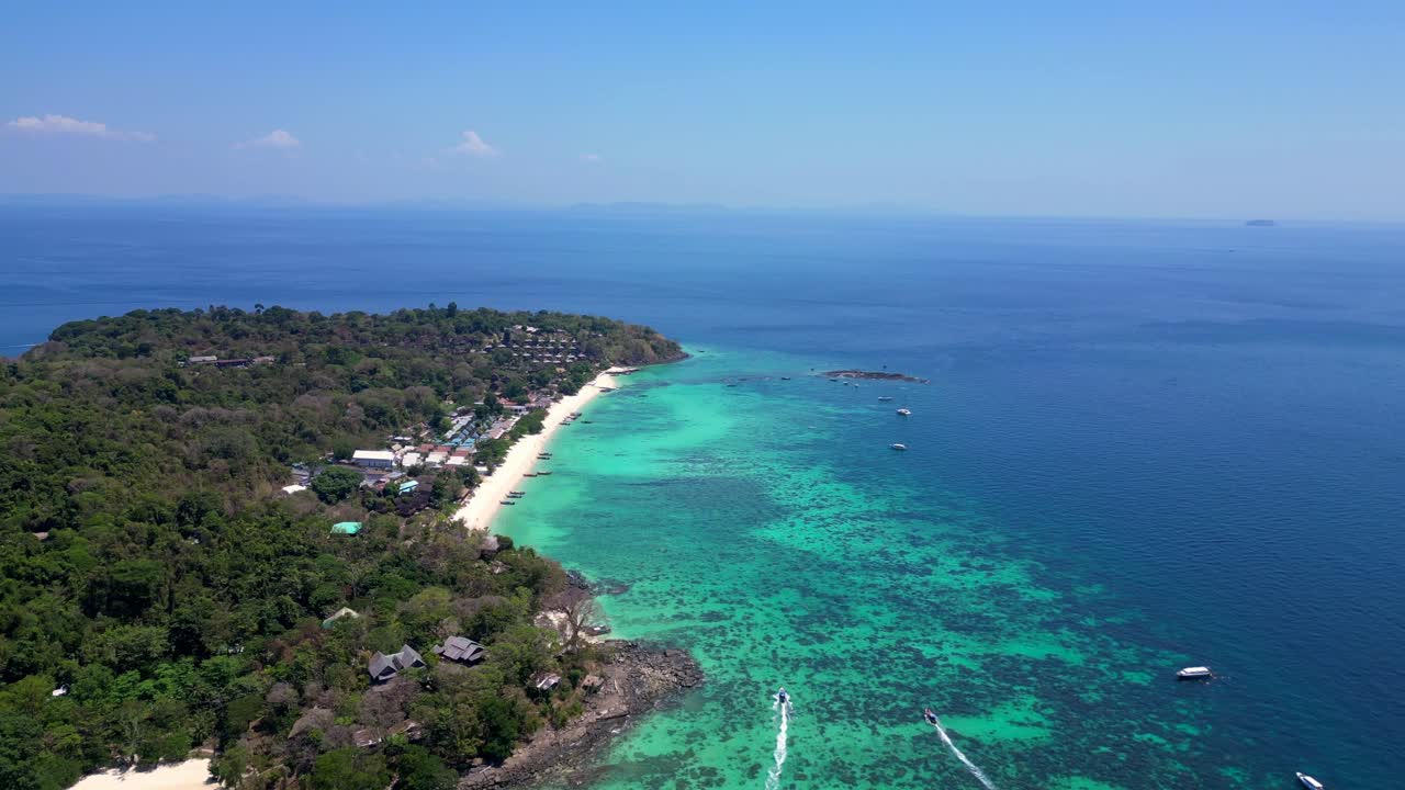vista aérea de la isla de phi phi con aguas turquesas, barcos, resorts de lujo y paisajes montañosos