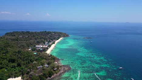 Aerial-view-of-phi-phi-island-with-turquoise-water,-boats,-luxury-resorts-and-mountainous-landscapes