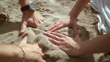 Hands-forming-heart.-Couple-hands-forming-heart-shape-on-sand