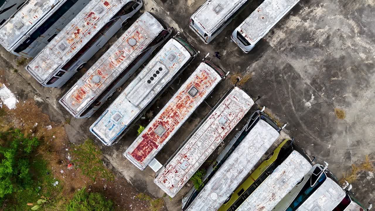 드론 영상은 푸켓의 황폐한 버스 정류장을 포착합니다. 황폐하고 방치된 지역에서 녹슬고 버려진 차량을 보여줍니다.