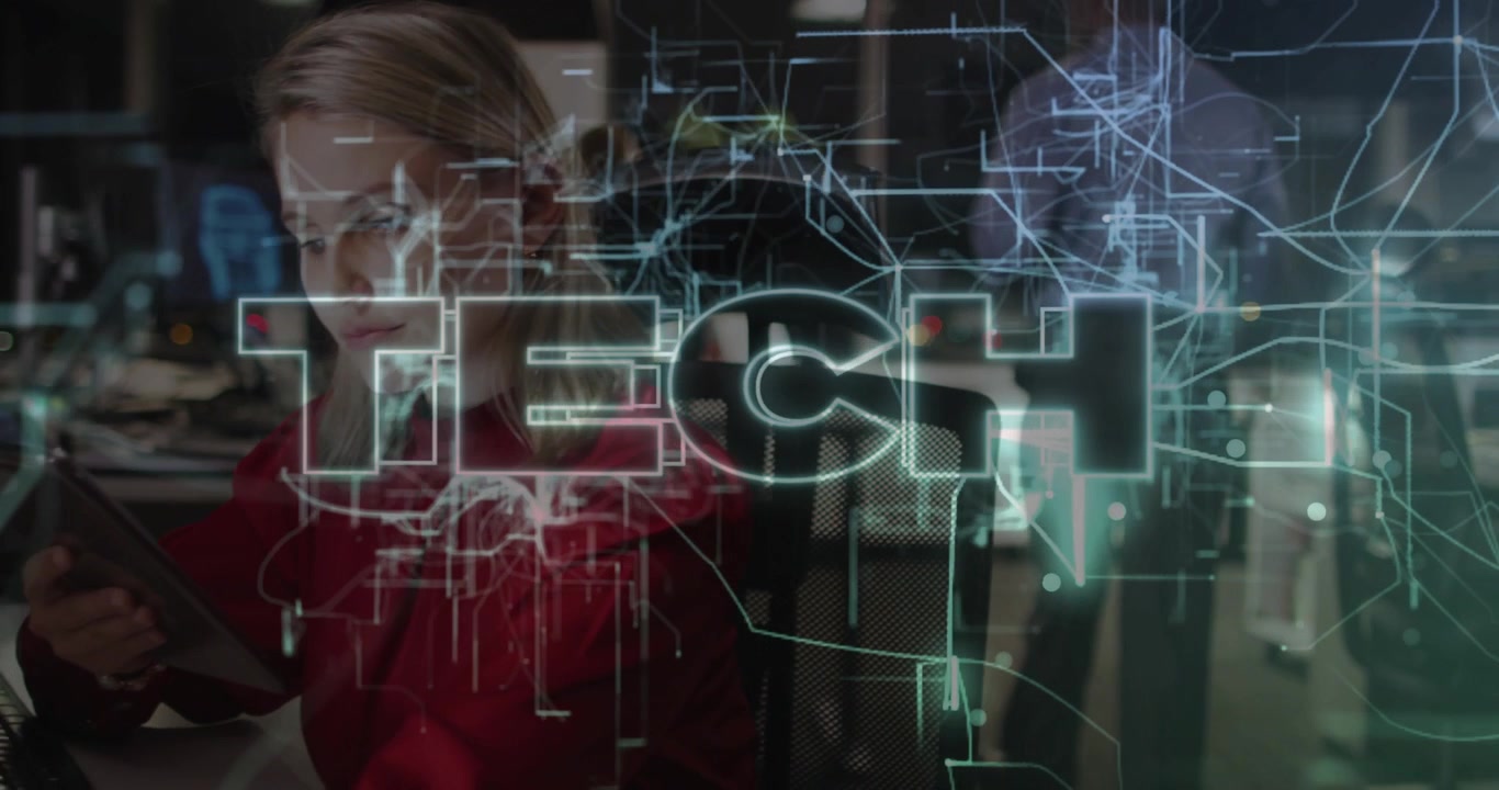 Software developer tapping tablet and analyzing data as TECH circuit lines appearing in tech office