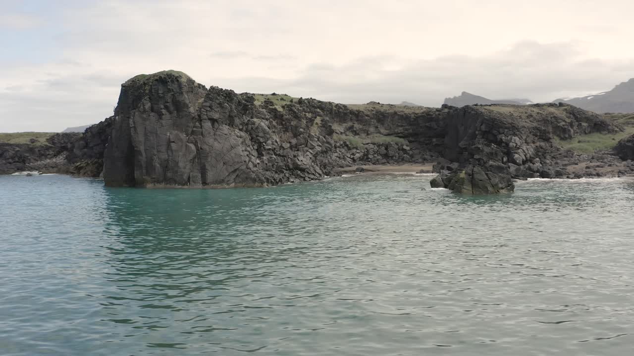 hermosos acantilados rocosos de la playa de skardsvik con aguas tranquilas del océano, círculo aéreo