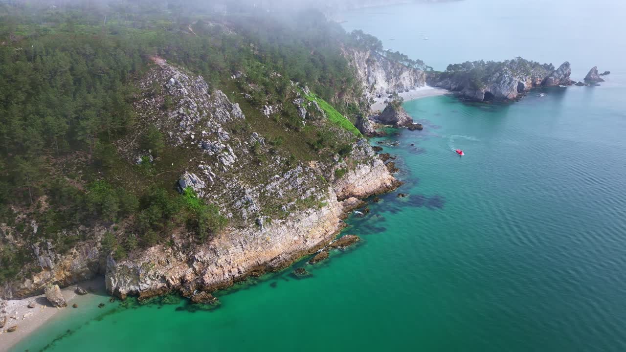Chuyển động lia máy bay không người lái từ những vách đá dốc và khu rừng sương mù vươn lên phía trên bãi biển Virgin Island ẩn mình, bán đảo Crozon, Brittany, Pháp