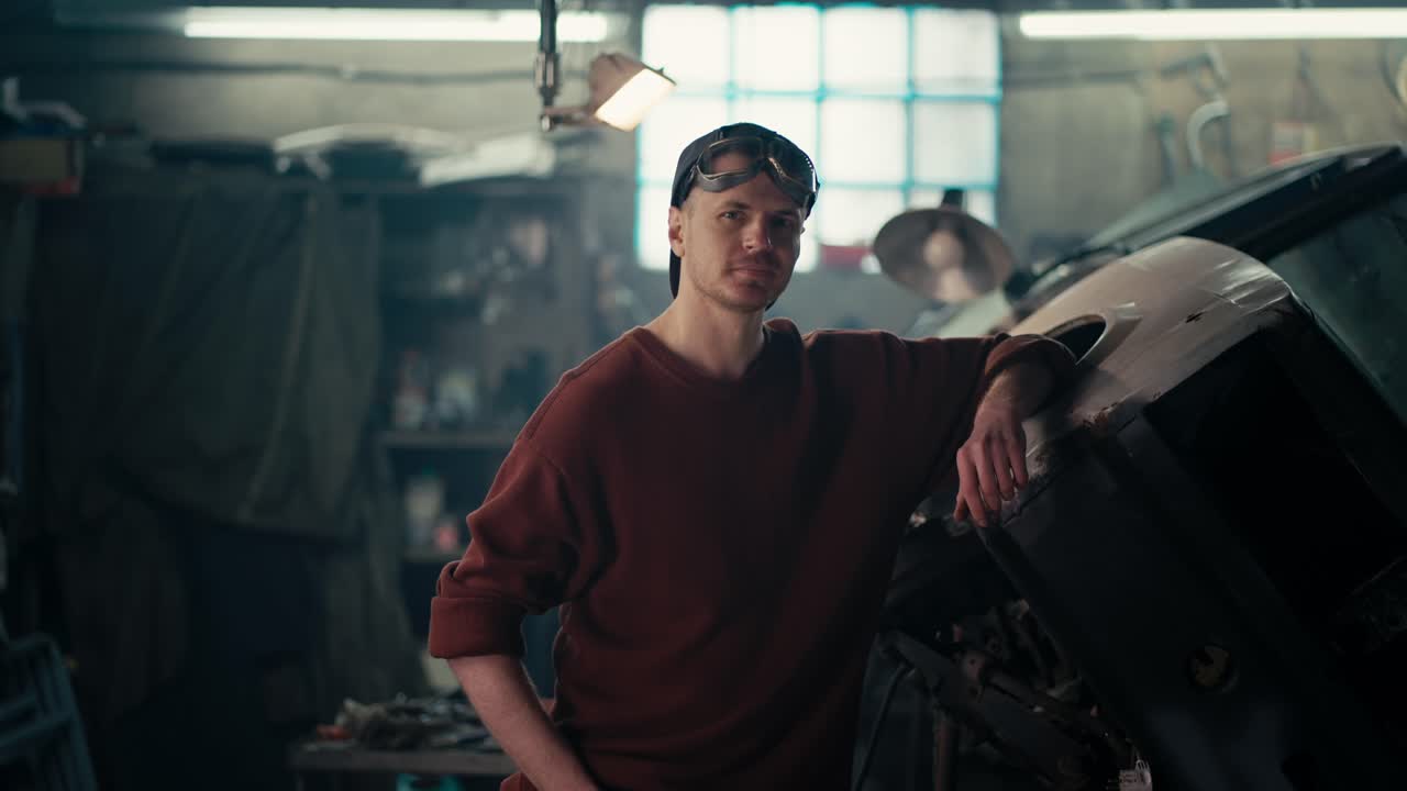 갈색 재 ⁇ 과 고글을 입은 용접 마스터가 배경에 서 있습니다.