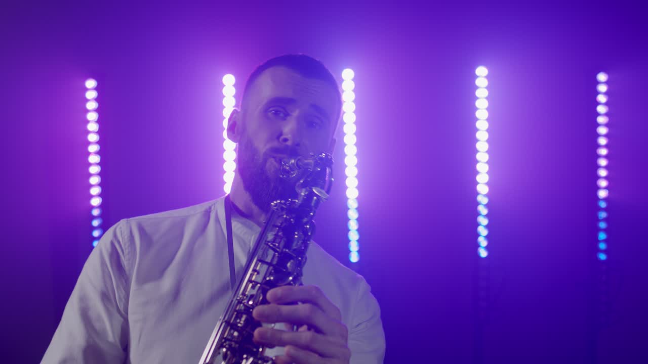 Esibizione dal vivo di un sassofonista con il sassofono, che balla sul palco di un concerto illuminato.