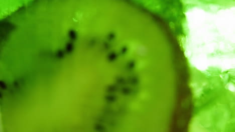 close-up of a kiwi slice in water with ice