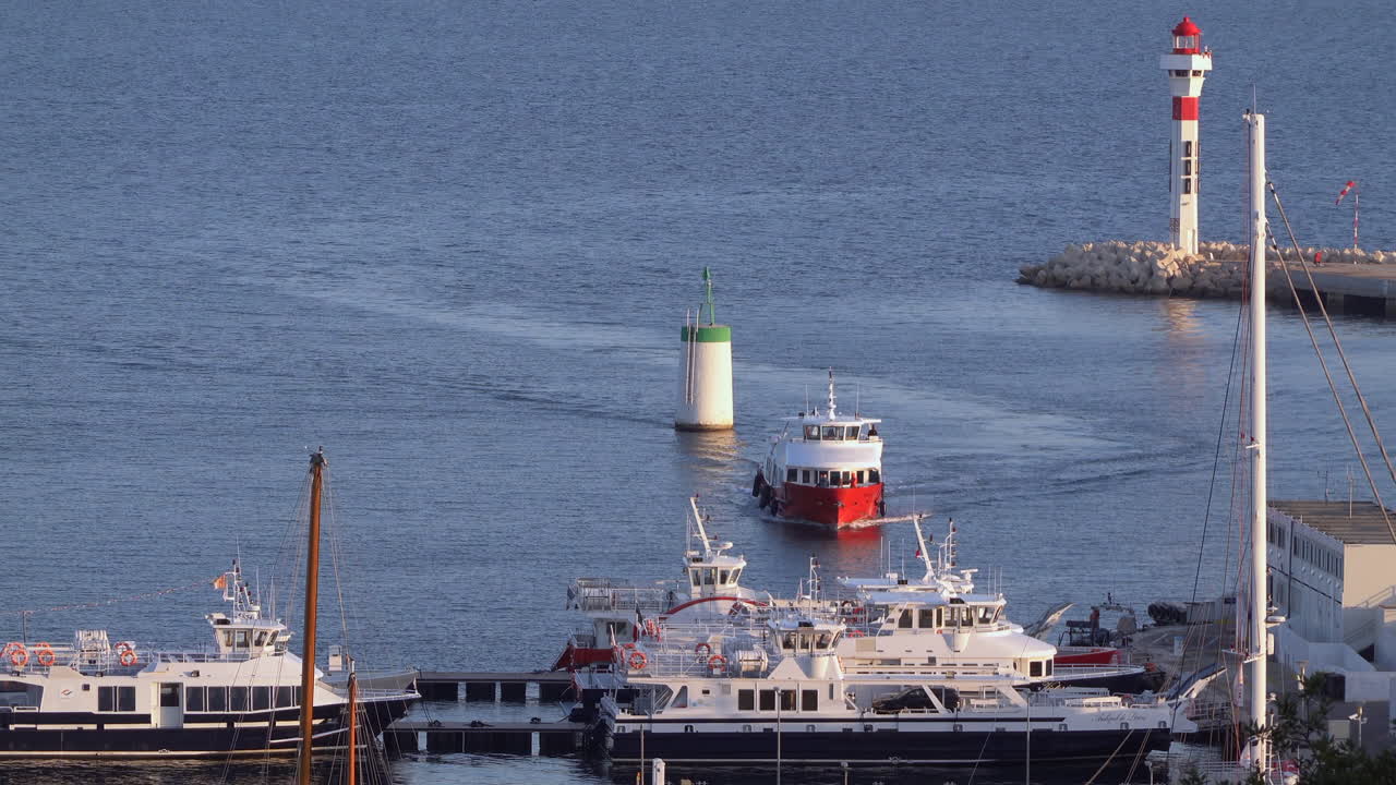Nice, France - March 17, 2025: View of a boat moving on the blue sea in daylight near boats docked in the harbour