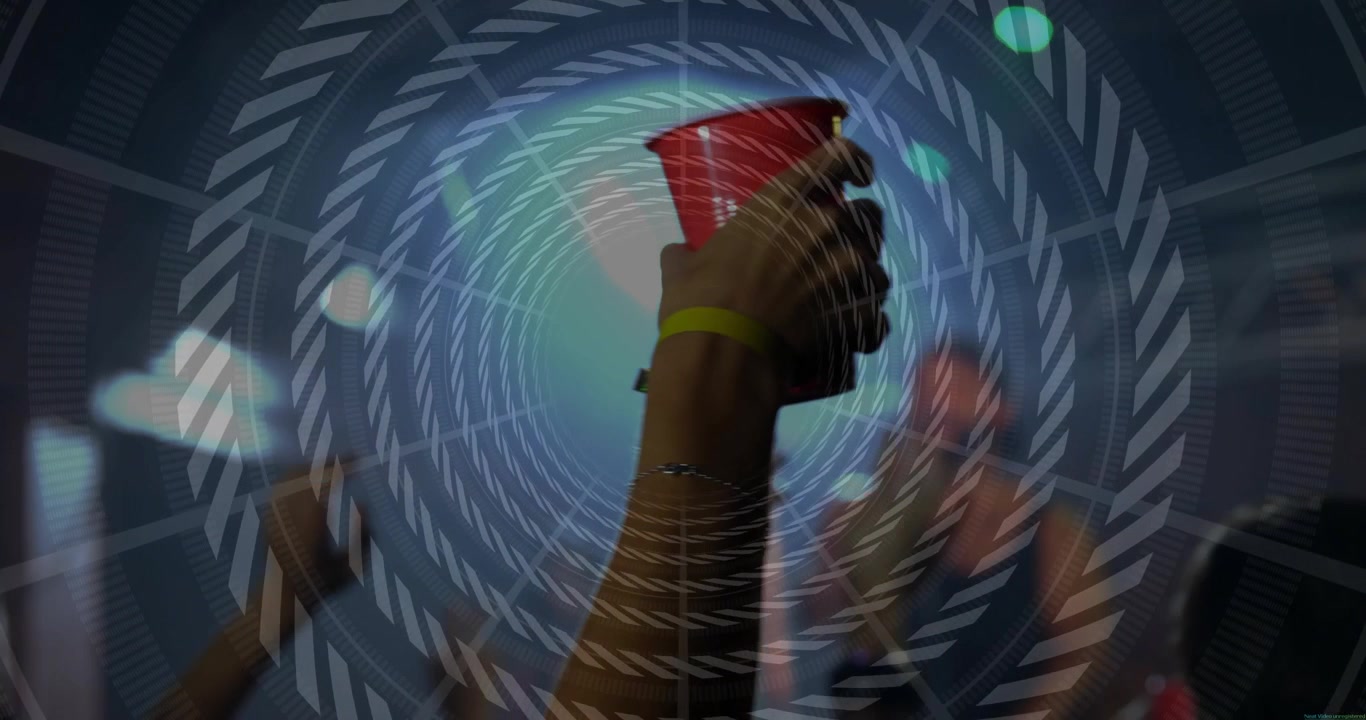 Fan con braccialetto che alza un bicchiere rosso, il calo del ritmo musicale spinge la folla ad alzare i bicchieri, con sovrimpressione di ripresa telefonica.
