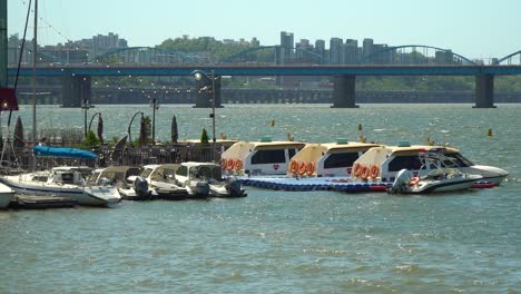 Boats-And-Yachts-Moored-At-Han-River-In-Seoul-With-Dongjak-Bridge-In-Background