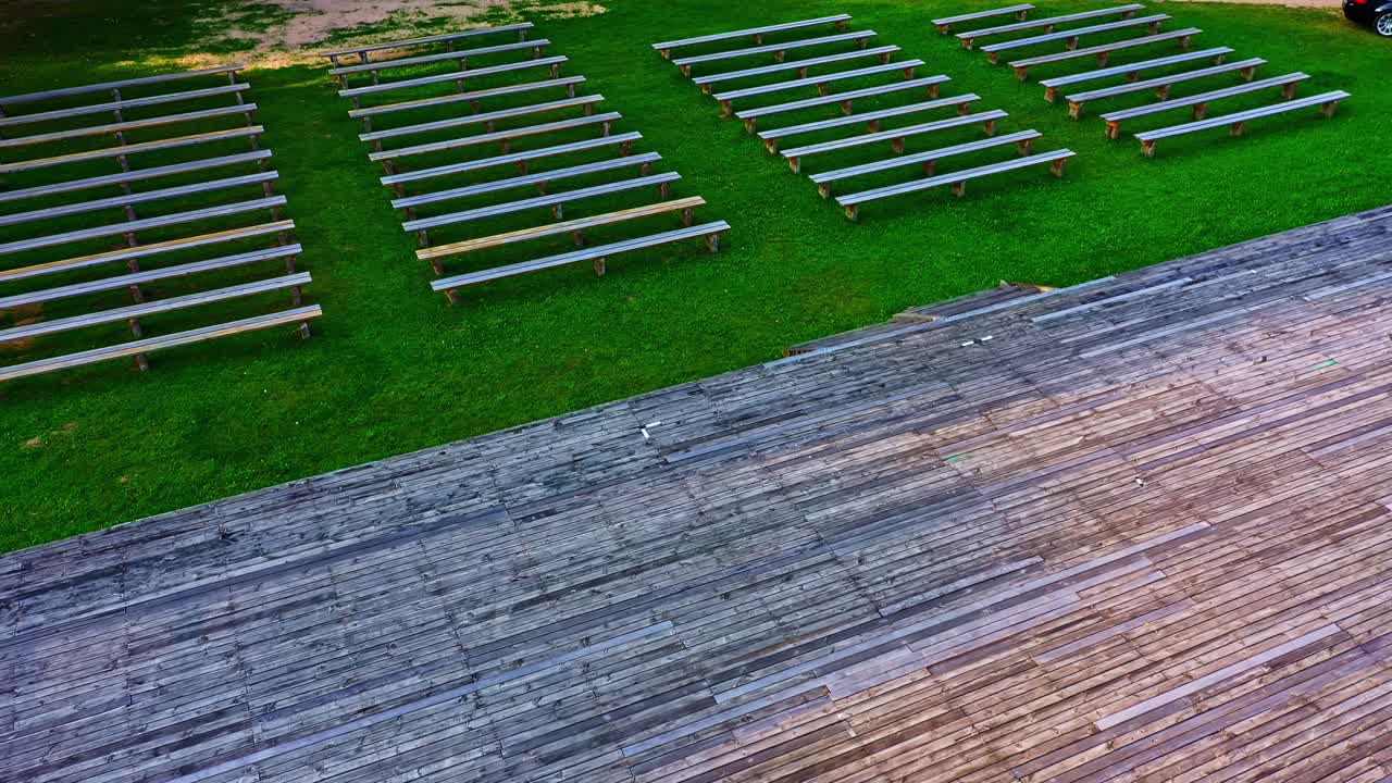 Flying Over Wooden Stage and Benches in Open-Air Theater on Warm Summer Evening