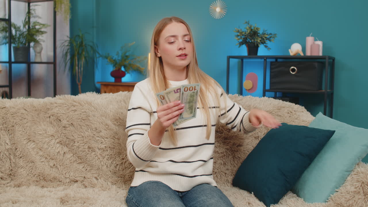 Caucasian woman finding lost dollar cash on sofa counting money searching missing banknote indoors