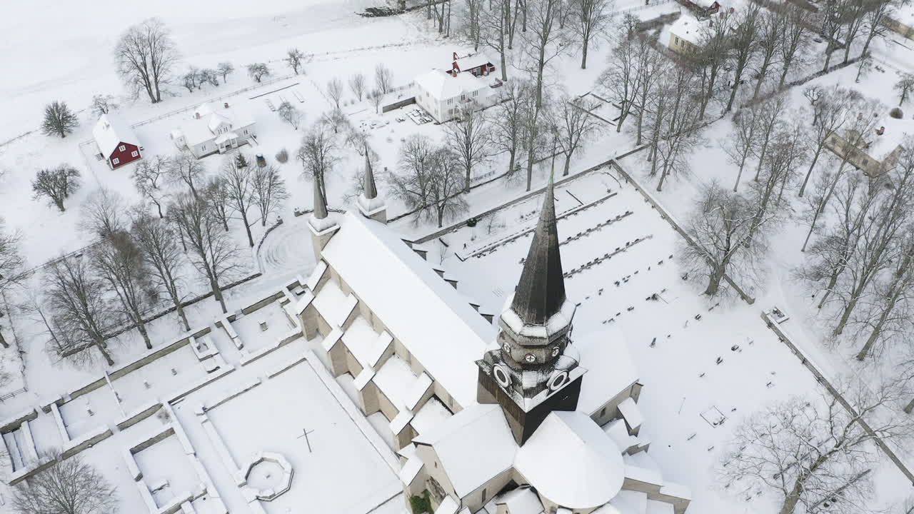 Aerial top view shot of a church and cemetery in the middle of the woods in Sweden