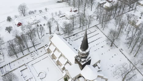 aerial top view shot of a church and cemetery in the middle of the woods in sweden