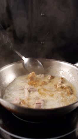 chef cooking meat in a pan