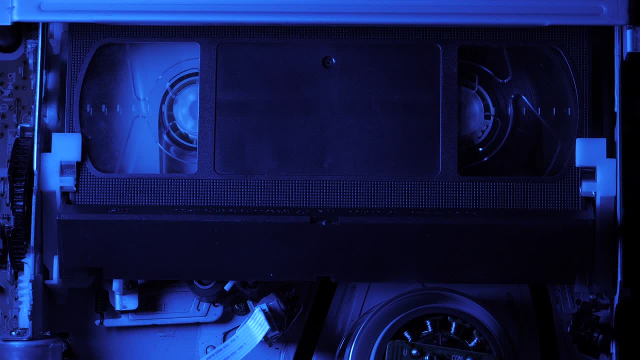 VCR VHS mechanics video cassette player insert tape magnetic head. Rotation reel with tape on the video, audio tape recorder or player. Closeup. Shallow depth of field. 4k