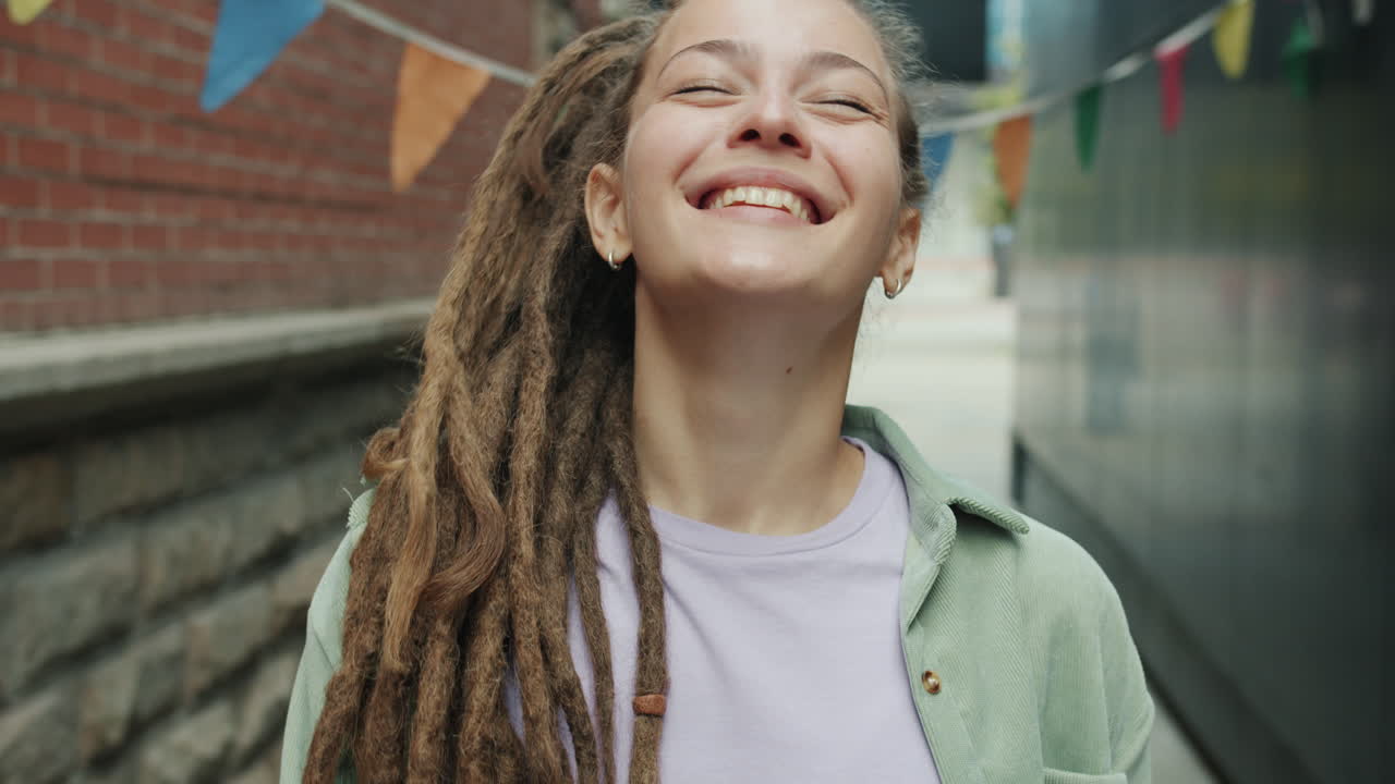 Smiling Woman with Dreadlocks in Urban Setting