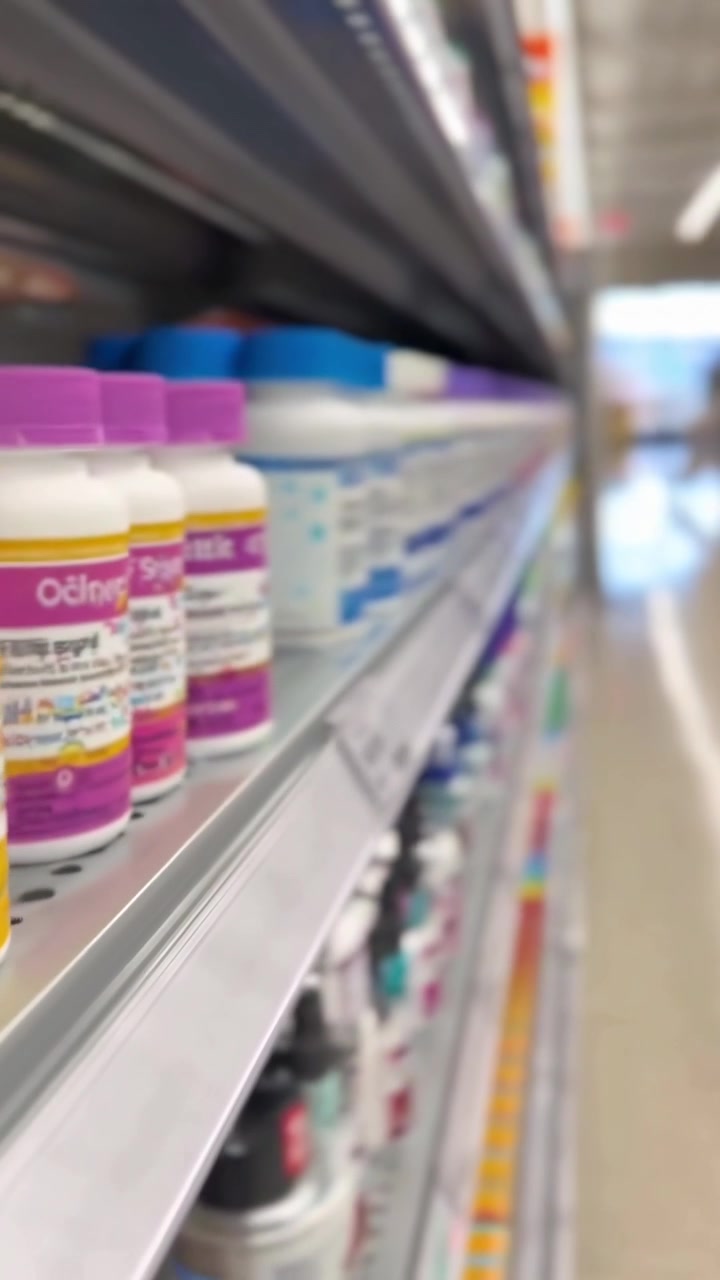 Flaconi Colorati di Farmaci e Integratori Esposti su Scaffale di un Negozio