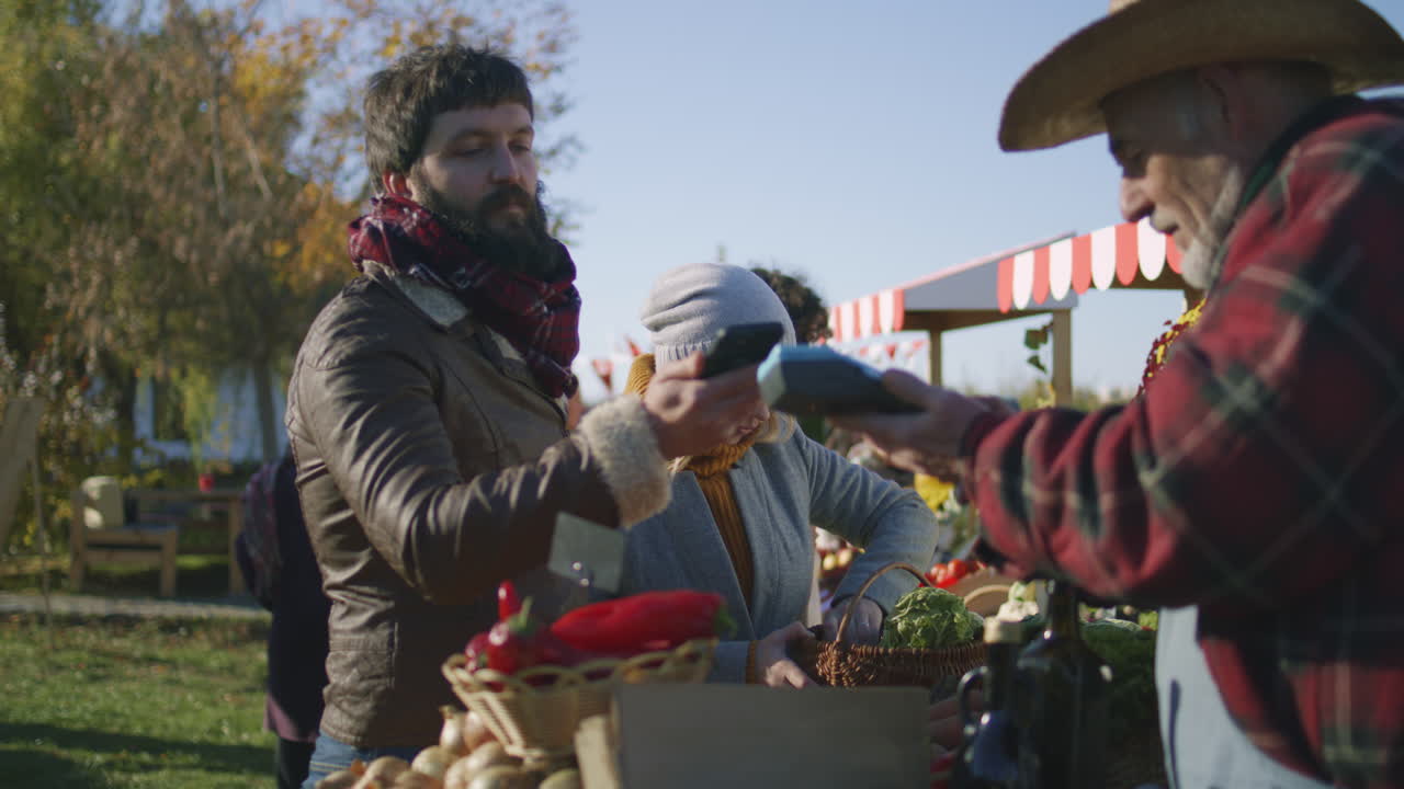 Customer paying for produce at a farmer's market using mobile phone