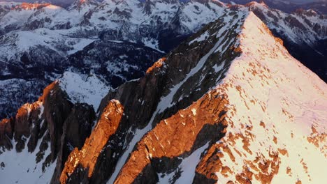 at sunrise a drone flies around the peaks of cima d'asta