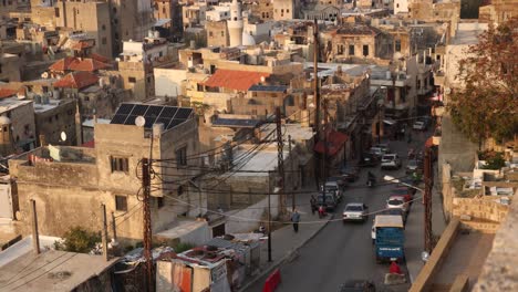 cars driving down an old road towards the historic arab old town of tripoli, northern lebanon