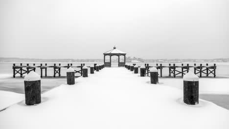 mirando hacia un muelle cubierto de nieve en un gran río congelado, tranquilo y quieto