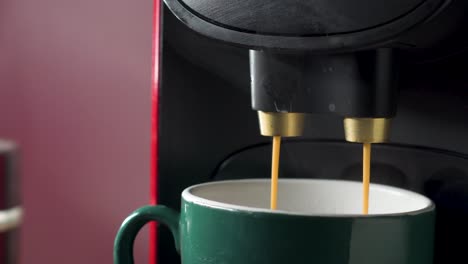 Electric-coffee-maker-filling-a-cup-with-coffee-at-home