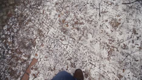 pies masculinos en jeans y zapatos de invierno caminando en la acera helada, cámara lenta