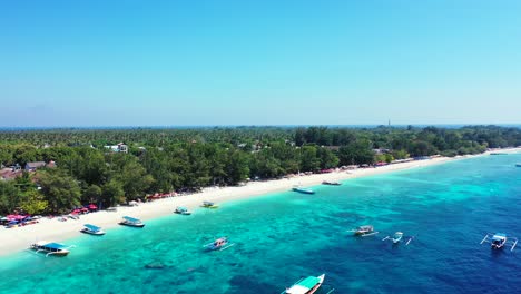 vivid colors of balinese island coastline with tourist boats floating over blue azure sea water near white sandy beach