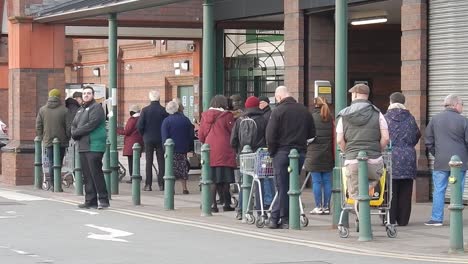 covid corona virus british social distancing queue at supermarket morrisons store part i
