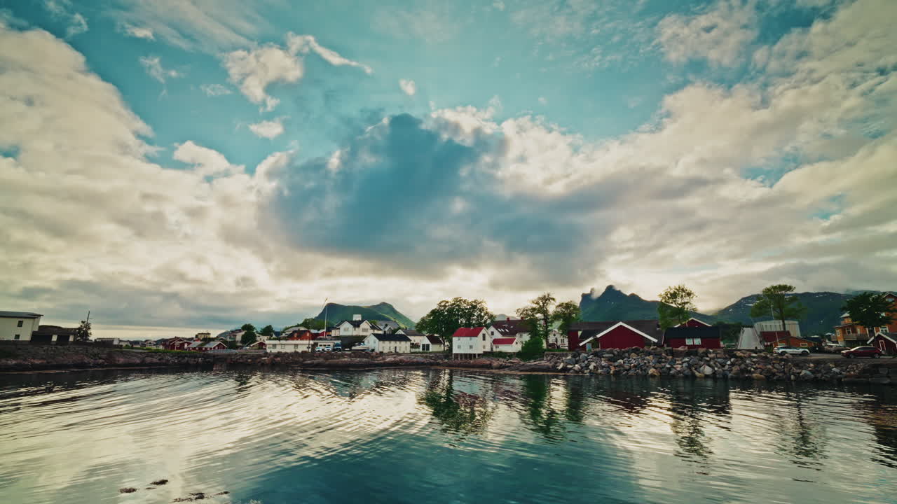 Panoramic view of a local nordic town in Norway. View of the wooden local buildings and the picturesque landscape. Sky reflecting on the still water.