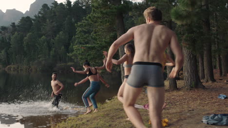 group of friends jumping in lake at sunset taking off clothes splashing water enjoying playful game young people celebrating on summer vacation