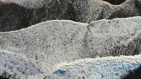 aerial view of foamy ocean waves crashing