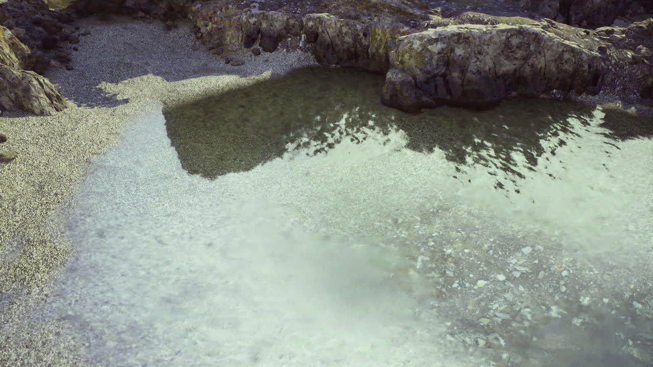 Calm waters reflect rocky landscape at a tranquil coastal location