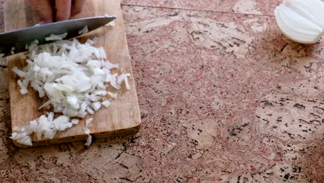 man gently cuts the onion into small pieces. man's hands close-up.