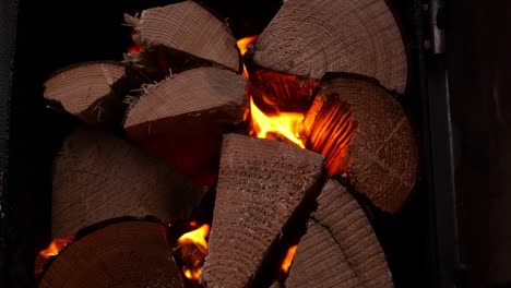 close up of pile of wood logs burning to heat hot tub