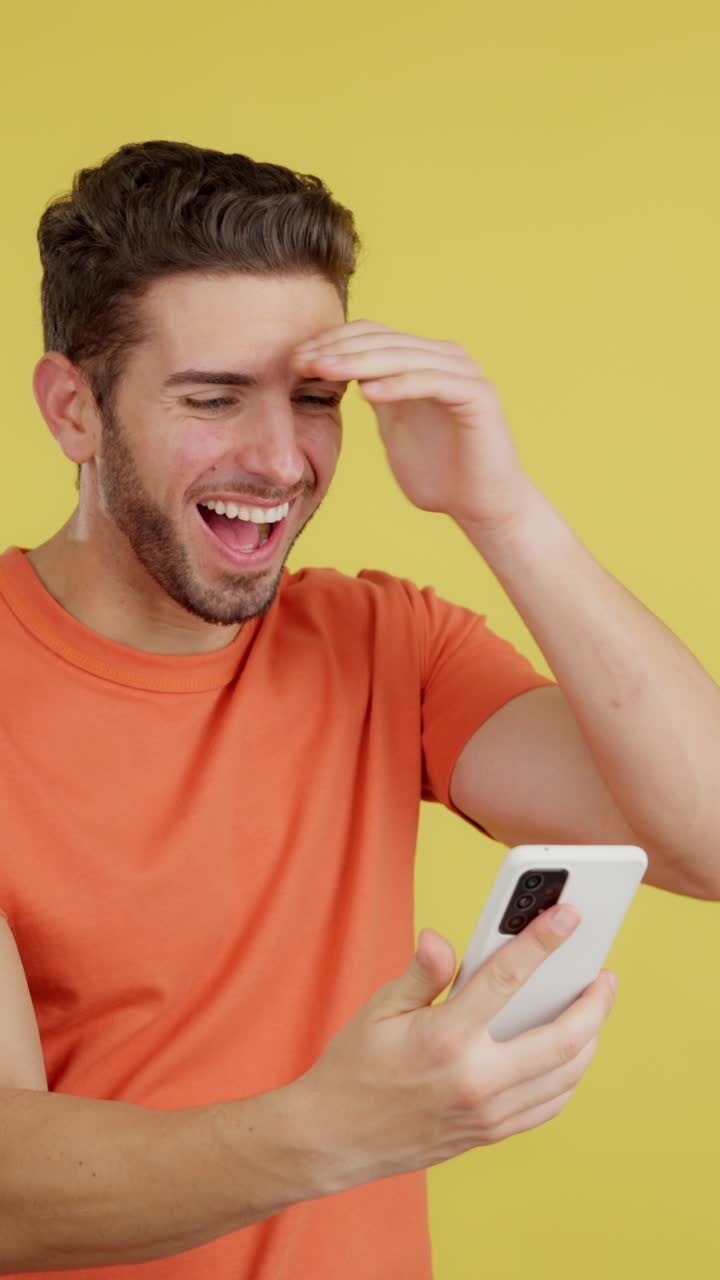 Man reacting with surprise and excitement while looking at his smartphone