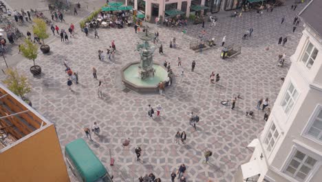 aerial view of a crowded city square with a fountain