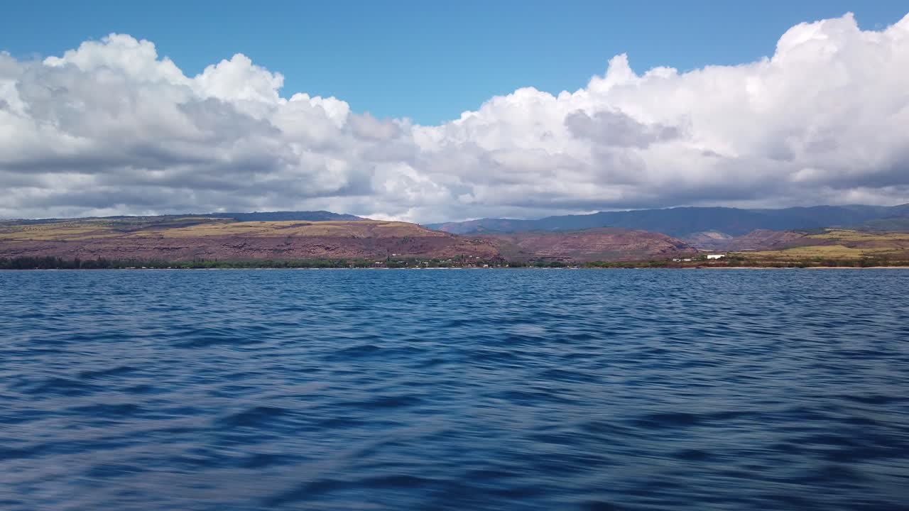 Gimbal wide shot from a moving speed boat of Waimea Canyon as seen from the open ocean off the coast of Kaua'i in Hawai'i