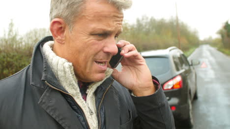 driver broken down calling recovery service on mobile phone