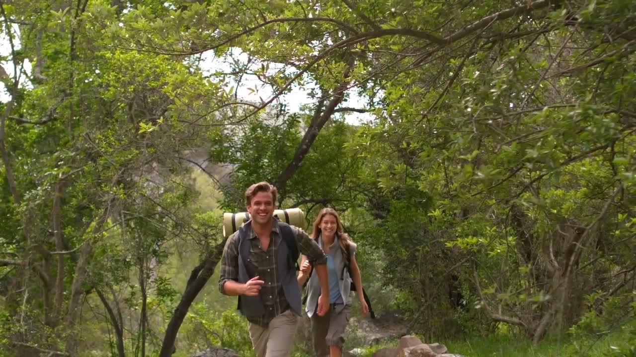 pareja sonriente en una caminata en el campo